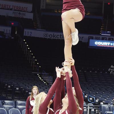 Clinton cheerleaders pump up the crowd during the “Court of Dreams” game at the Paycom Center in Oklahoma City as Jaycee Rodebush, left, Presley Evans, back, and Mia Coxwell, center, hold up Addison Newcomb in a tower formation. CDN | Sam Goodwyn