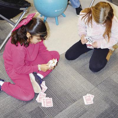 Second-graders Mia Esparza, left, and Violet Lofland play cards inside a classroom at Southwest Elementary School last week since it was too cold to play outside. CDN | Michael Maresh