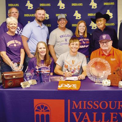 Nate Hickey, seated at center, signs his National Letter of Intent to compete in shooting sports for Missouri Valley College. Seated with him, from left, are his mother Erin Hickey, MVC coach Shawn Dulohery; standing, Mitchell Hunter, his grandmother Nanc