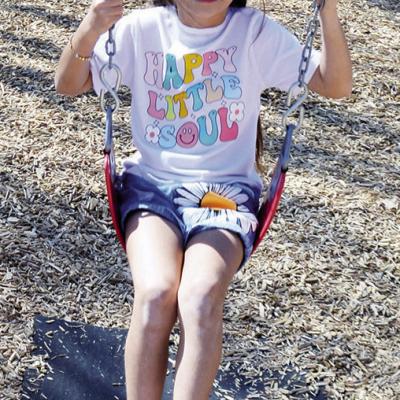 Aylieea Brown, 7, enjoys the nice weather while swinging.
