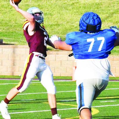 Senior quarterback Cooper Sulley gets the ball off in time to avoid the Newcastle defender. CDN | John Kinsey Red Tornadoes look to battle Kingfisher