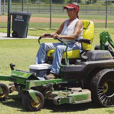 Sherrill Ausmus mows the grass at Schumacher Fields at Acme Brick Park Tuesday as the town prepares to host the OK Kids 8U Softball State Tournament starting today. CDN | Christian Jacobsen