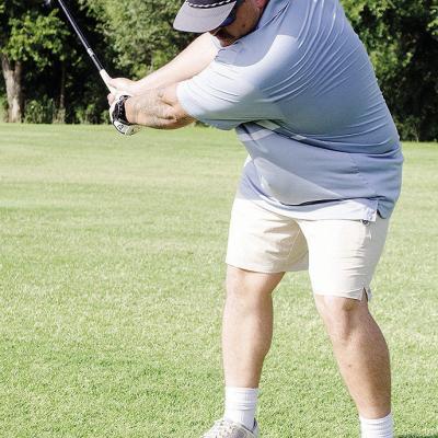 Austin Long raises his golf club as he prepares to hit the ball at Riverside Golf Course. CDN | Sam Goodwyn
