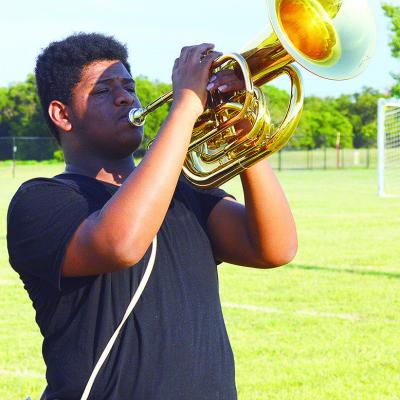 Kristian Bennett holds at attention during an after-school marching band rehearsal for the Pride of Clinton Monday evening. CDN | Micah Ashcraft