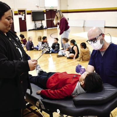 Joanna Martinez, WTC dental assisting student, left, records Dr. Kyle Serfoss’ findings while examining Alejandro Quezada recently at Nance Elementary.