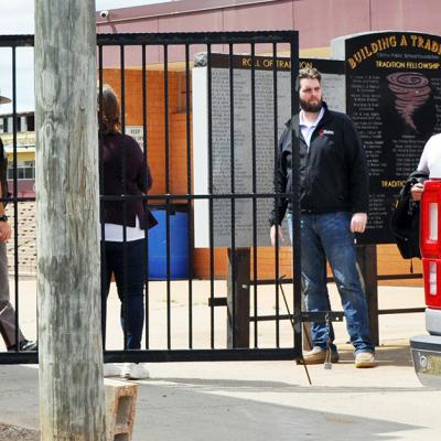 From left, Oklahoma Highway Patrol Lt. Aaron Hunter, Clinton Public Schools Assist. Supt. Melissa Knabe, Clinton Police Department Detective Paul Sperle and Detective Calvin Ramirez secure the north entrance to the Tornado Bowl Friday. CDN | Staff Photo