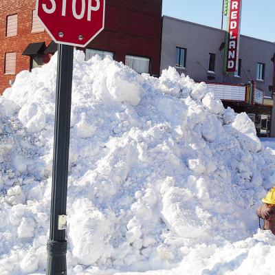 One of the many piles of snow plowed up as high as stop signs Monday morning after being cleared off the road at the intersection of Sixth Street and Frisco Avenue. CDN | Micah Ashcraft