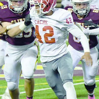 Riley James No. 59 and Dakoka Elizondo block Christian Bennett No. 42 from Cache. CDN | John Kinsey Clinton to host one-win Woodward team