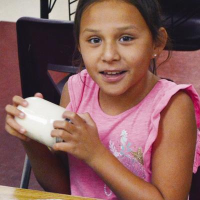 Kyiah Lime shakes the jar of milk as fast as she can to help make it into butter Wednesday during the Discovery Zone class at Washington Elementary. CDN | Christian Jacobsen