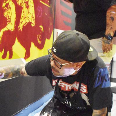 Swab Gonzalez, front, and Talllly Lopez decorate the Clinton Fire Department’s Day Room with a mural displaying more than 100 years of Clinton firefighting. CDN | Caleb Blanchard Local artists