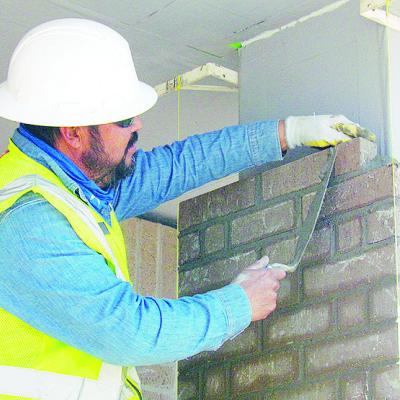 Carlos Quilantan places bricks on a column Wednesday at the Troop H Oklahoma Highway Patrol Headquarters construction site. CDN | Christian Jacobsen