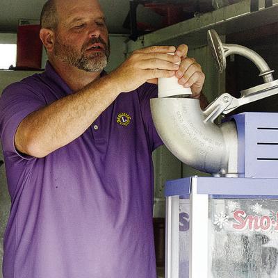 Brett Brittain fills the snow cone maker in the concession stand between the T-Ball fields during the Noon Lions games at Acme Brick Park. CDN | Sam Goodwyn