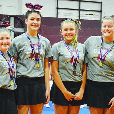Clinton Middle School cheerleaders, from left, Maysen Mosburg, Chanel East, Harmonee Cates, and Lily Starnes accept their medals for being selected All-American after their summer cheer camp last Thursday at the CMS Auditorium. CDN | Micah Ashcraft