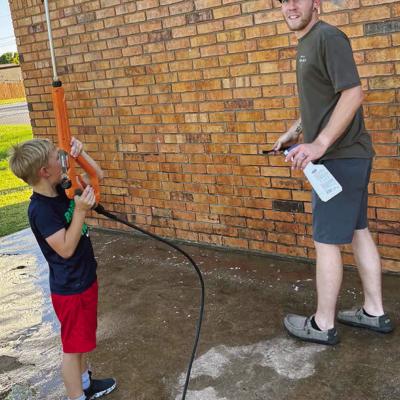 Timothy Sorter, left, is ready to finish pressure washing the walls of the Legion Field baseball concession stand with his dad Kyler Sorter at McLain Rogers Park. CDN | Courtesy photo
