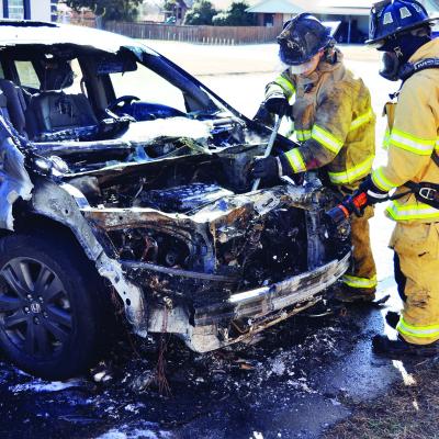 Clinton Firefighters Bobby Winans and Alex Tyler make sure this torched van does not reignite Monday afternoon in the 1600 block of Dunn Avenue. CDN | Staff Photo