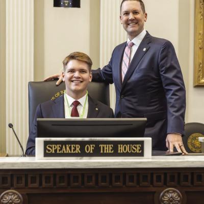 Preston Payne, left, sits at the chair of the Speaker of the House with Speaker Pro Tempore Anthony Moore after returning to page. CDN | Courtesy photo