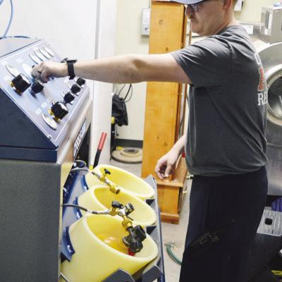 Clinton Firefighter Collin Wieder fills up a SCBA tank to put it back in service. CDN | Michael Maresh