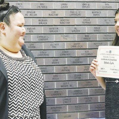Sara Whiteshield, left, library manager, presents Mikinley Keith with her babysitting certificate during the class’s graduation ceremony. CDN | Elisha Rangel Babysitting Course Concludes Successfully
