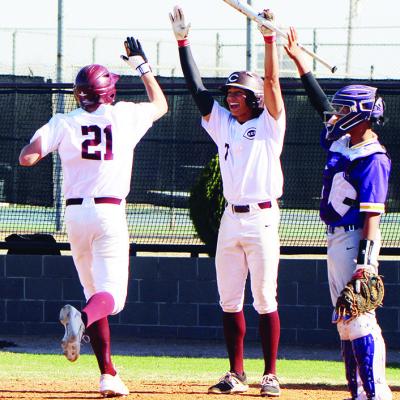 No. 21 Ayden Crumley crosses home plate to receive a high five from DeAndrae Fanshier after scoring an inside-the-park homer against Anadarko. CDN | Emily Stephens Reds pound Anadarko in district opener