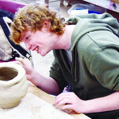 Junior Wylder Smith puts the finishing touches on his clay project in Clinton High School’s Art 3 class. CDN | Michael Maresh