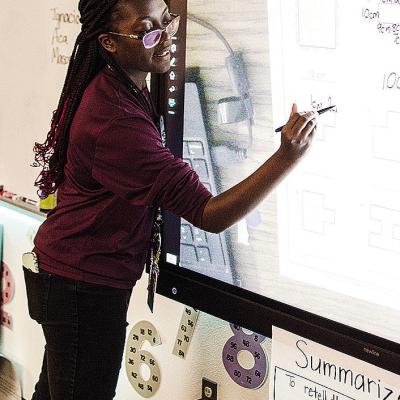 Jessica Jefferson writes on the smart board as she teaches math during school at Southwest Elementary School. CDN | Sam Goodwyn