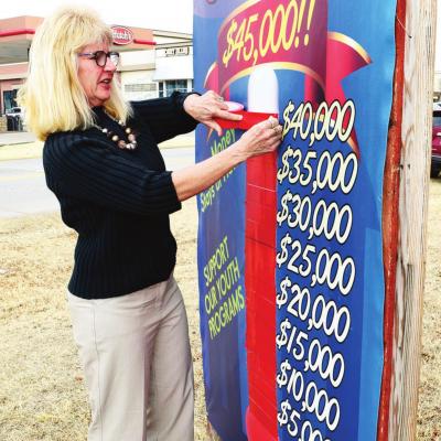 Debbie Carlisle adjusts the Clinton United Fund sign to show how much has been donated. CDN | Litzy Silos Trust donates $19,000 to United Fund