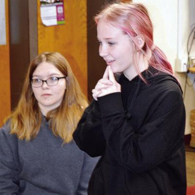 Eighth-grader Sophie Stewart, right, thinks it through in spelling the word “gravelly,” a word she had never heard of before, at the Clinton Middle School Spelling Bee Tuesday to win the bee. Karly Wilson, left, opened the door for Stewart when she mi