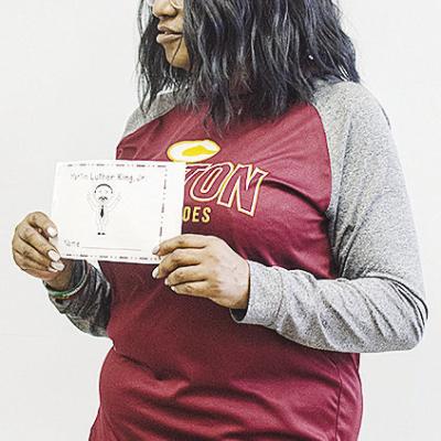 Tosha Jones instructs her students on what to do with the Martin Luther King Jr. coloring book as they celebrate Black History Month at Eastside Academy. CDN | Sam Goodwyn
