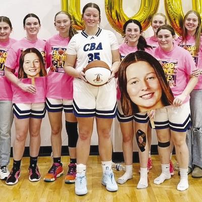 The Corn Bible Academy Lady Crusaders celebrate as Kate Stewart, center, scored her 1,000th career point for CBA on a threepoint shot during the Lady Crusaders’ 60-56 overtime loss last Friday to Pioneer-Pleasant Vale during the Burlington Tournament. P