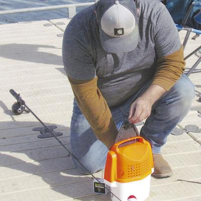 Martin Vela preps his fishing equipment at Acme Brick Park. CDN | Christian Jacobsen