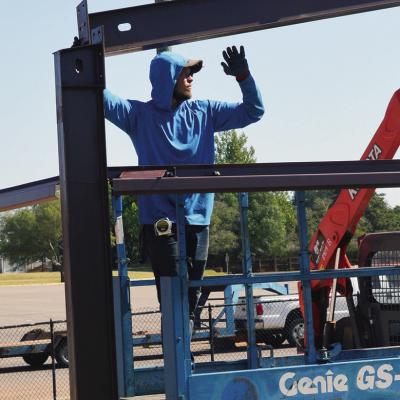 Drake Carnes lines up the frame of the new equipment shed Tuesday at Clinton High School near the weight room and track. CDN | Christian Jacobsen