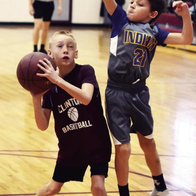 Kaisan Thompson, left, goes in for a shot while Riggins Pruitt attempts to block it during a basketball game conducted by the Clinton Youth Basketball League. CDN | Emily Stephens Rising Stars