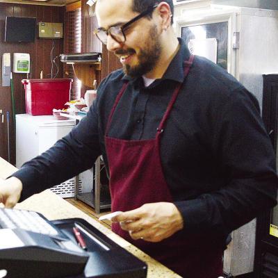 Cesar Lopez checks out a customer behind the register Wednesday evening at the new location for Pedro’s Mexican Food. CDN | Micah Ashcraft