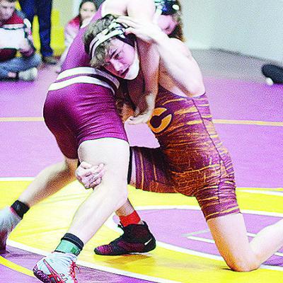 Clinton’s Landon Wilson, right, attempts a fireman’s carry of his opponent during the District Duals held at the Tornado Dome. CDN | Sam Goodwyn