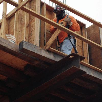 Gueybor “Jiro” Atilano Martinez removes wooden walls that held the form of freshly poured concrete on the Interstate 40 overpass support beam Tuesday at Neptune Drive. CDN | Christian Jacobsen