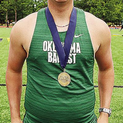 Former Clinton track and field athlete Wyatt Willougby smiles as he shows off his medal from a meet this year with Oklahoma Baptist University. CDN | Courtesy photo