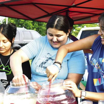 Students with the St. Mary’s Youth Group stir lemonade and other beverages at their booth at McLain Rogers Park during each Friday’s Levitt Amp Clinton Concert Series. They are from left, Stacey Franco, Ashley Rivera and Vanessa Barco. CDN | Nydia Cam Refreshing drink