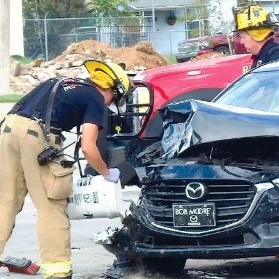 CDN | Robert S. Bryan Clinton fireman Lt. DJ Woodall pours absorbent onto the impact area where a car driven by Clinton resident Phoenix Brown was hit Sunday by a pickup driven by a Taloga man. At right is another Clinton firefigh Illinois girl hurt in Foss wreck