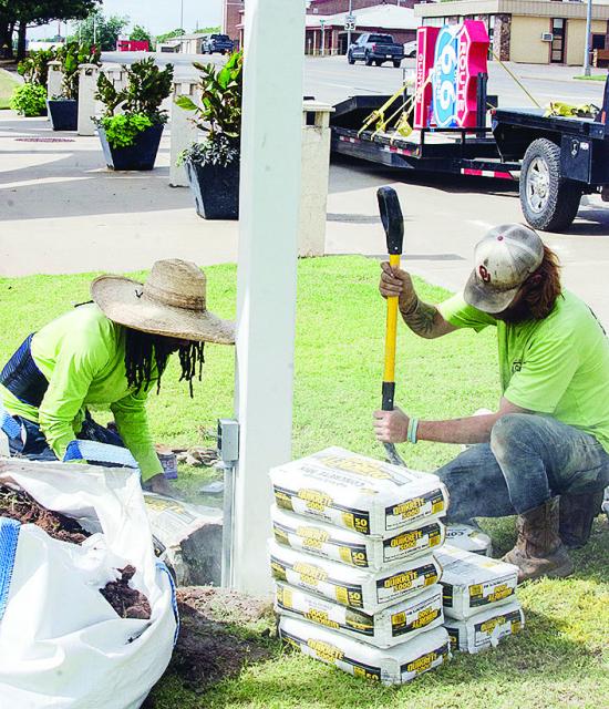 Cameron Jones, left, and Caleb Mabry work on cementing the pole in place Thursday that will hold a new Route 66 centennial sign outside of the Frisco Center. It’s visible on the trailer in the background. CDN | Sam Goodwyn Cameron Jones, left, and Caleb Mabry work on cementing the pole in place Thursday that will hold a new Route 66 centennial sign outside of the Frisco Center. It’s visible on the trailer in the background. CDN | Sam Goodwyn