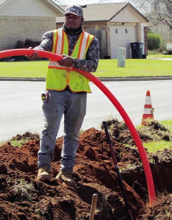 Cesar Reyes places fiber optic cables at Acme Brick Park. CDN | Christian Jacobsen