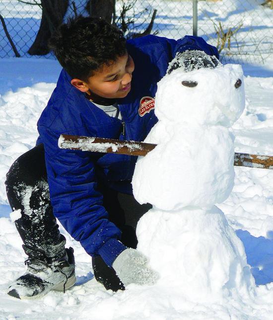 Jakob West enjoys the winter weather by making a snowman in his backyard Monday afternoon. CDN | Micah Ashcraft