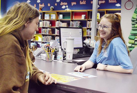 Myra Whitney, left, receives help signing up for the 2026 WPLS Winter Reading Challenge from Librarian Madison Wright at the Clinton Public Library. CDN | Micah Ashcraft