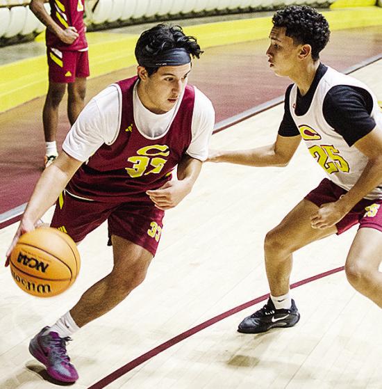 Clinton’s Sutton Hernandez, left, drives the ball against Jason Lloyd during practice in the Tornado Dome. CDN | Sam Goodwyn