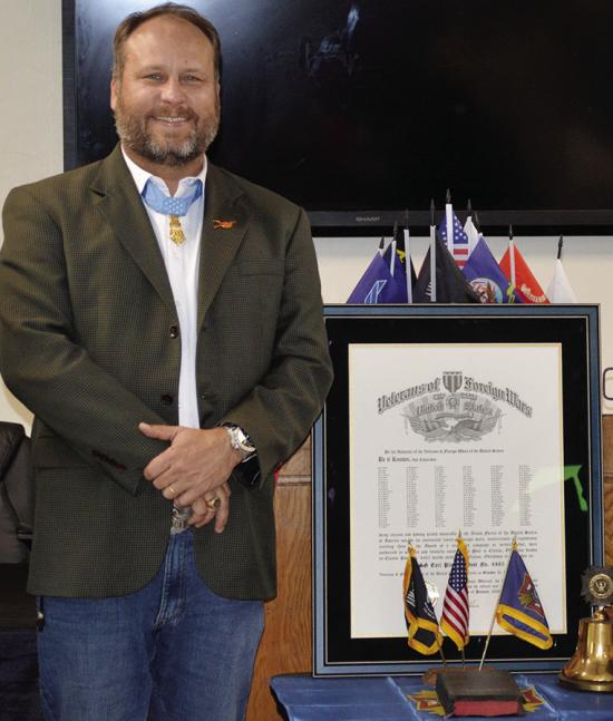 Master Sergeant Earl Plumlee stands next to the new building charter for the MSG Earl Plumlee Post 4465 Tuesday in the Clinton VFW. CDN | Christian Jacobsen