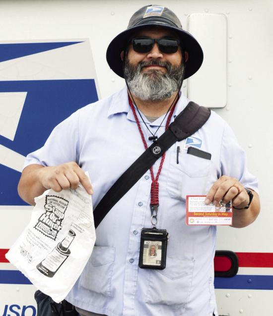 Mail Carrier Matthew Lantz drops off plastic bags to residents during his morning route for the Stamp Out Hunger Food Drive in Clinton. CDN | Christian Jacobsen