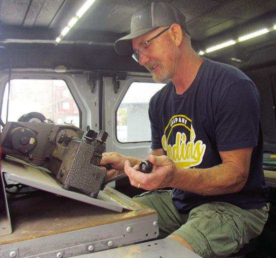 Lomax Lee of A-OK Lock &amp; Key cuts and shapes a new house key for a customer in the A-OK work van. CDN | Christian Jacobsen