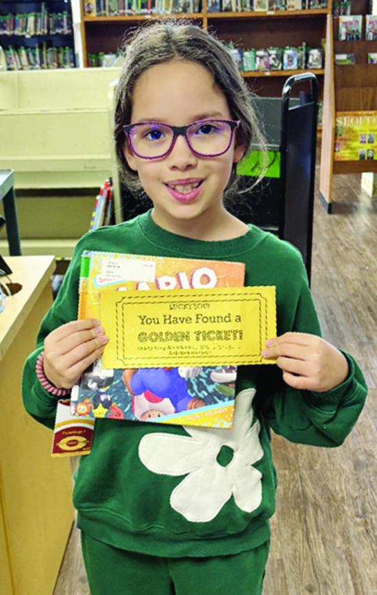 Nellie Brinkley shows off her “Golden Ticket” she found tucked away in her library book at Southwest Elementary during Read Across America Week. She and other lucky winners qualify for goodie bags. The school’s library has been engaging students all