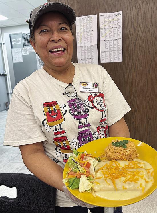 Dolores Torres holds her regional-winning dish, chicken fajita enchiladas, at Nance Elementary. CDN | Courtesy photo