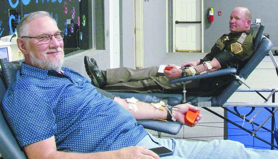 Tim Ruyle, left, and OHP Cmdr. Chance Husted donate double the amount of blood Tuesday for the Our Blood Institute blood drive at First Christian Church. CDN | Christian Jacobsen