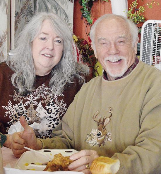 Tommie Walker and Bill Walker smile together as they enjoy a free meal during the H.O.S.T. Ministries’ Community Christmas Meal. CDN | Micah Ashcraft